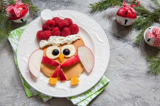 en lille fugl til morgenmad lavet med pandekager og frugt