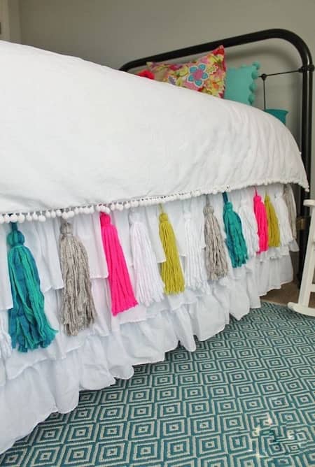 els pompons de colors donen a un conjunt de llit un aspecte juvenil