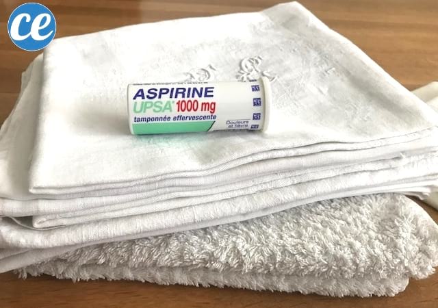 Un tub d'aspirina UPSA col·locat sobre una pila de llençols blancs per blanquejar-los
