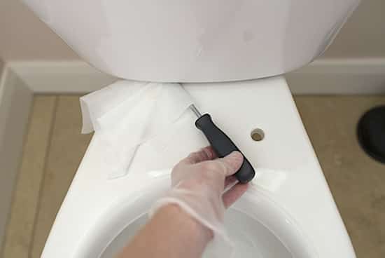 desinficer undersiden af ​​toilettet med servietter