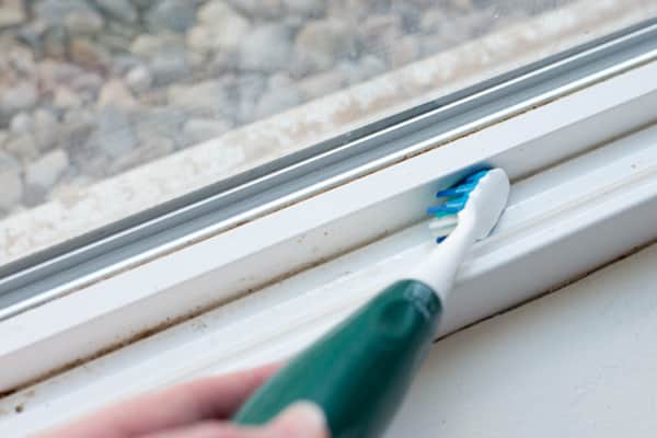 Use un cepillo de dientes viejo para limpiar los rieles de la ventana.