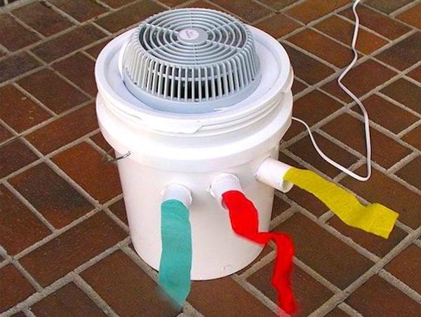 Aire acondicionado casero con balde de plástico y ventilador.