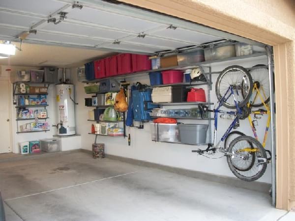 Colgar bicicletas y cajas de almacenamiento de plástico en un garaje.