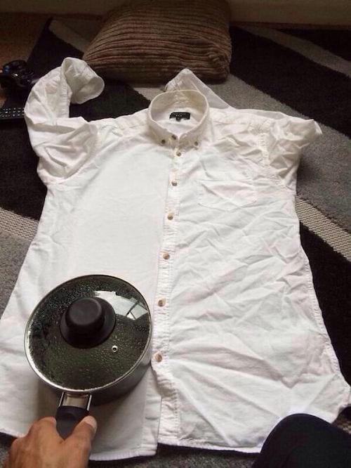 Planchar una camisa con una olla de agua caliente.