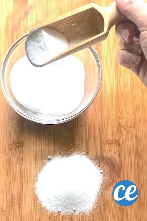 Bicarbonato de sodio en una taza y sobre una tabla de madera