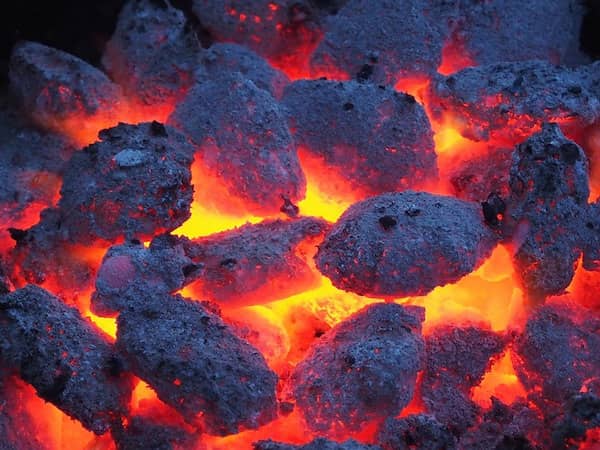 el calor quema los residuos de carne en la parrilla para que quede limpia