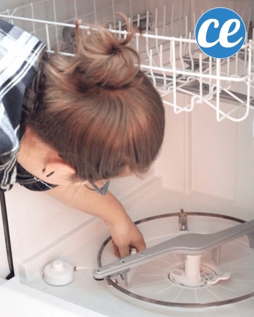 Mujer limpiando los filtros de su lavavajillas.