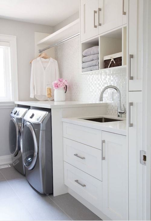 Un lavadero en tonos blancos y grises con azulejos de mosaico.