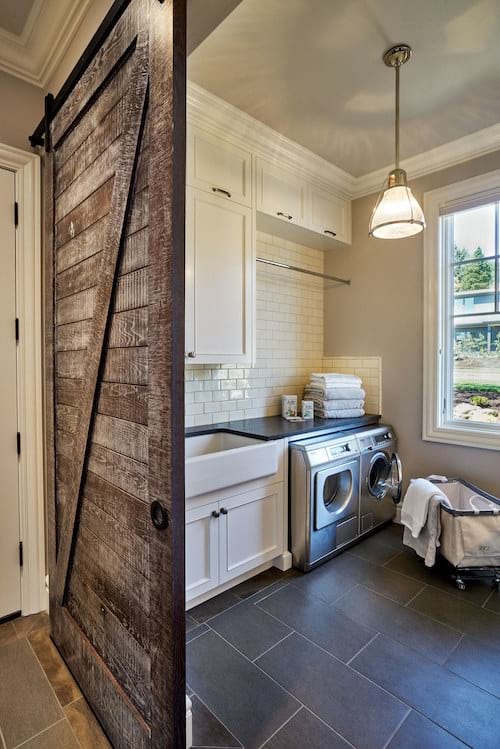 Un lavadero de estilo rústico con una hermosa puerta corrediza de madera.