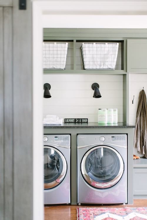 Hermoso y espacioso lavadero con almacenaje superior verde.