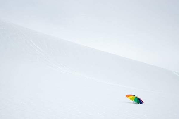 En enkelt parasol plantet i et bjerg af sne