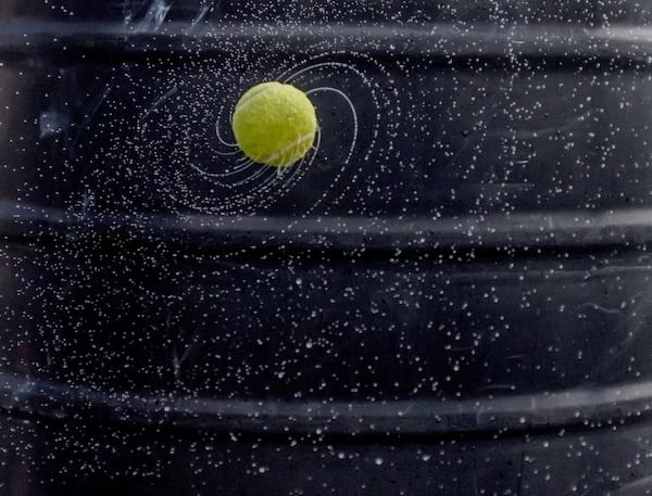 Pelota de tenis lanzando agua en círculo