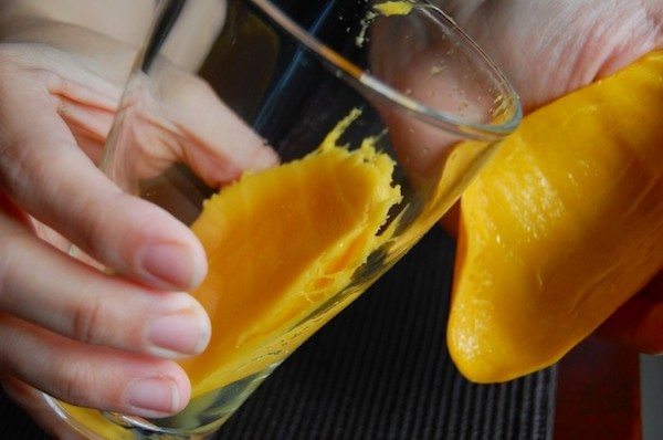 En mango skrællet rent takket være et glas