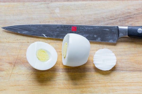 et hårdkogt æg skæres med en skarp kniv 1/3 øverst og en tynd skive i bunden