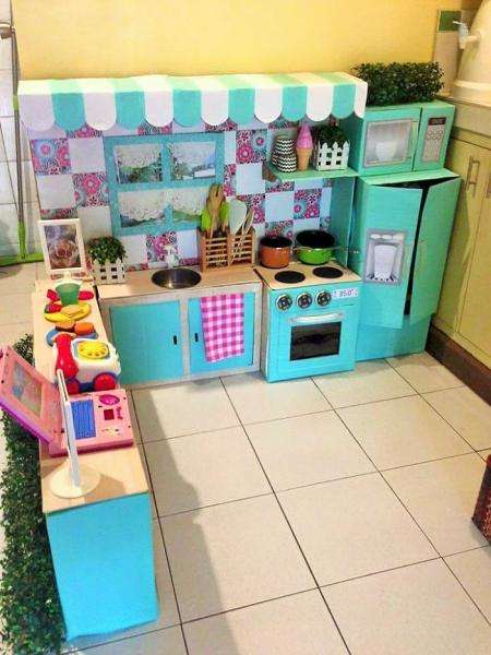 Pon (-y) un comedor y juguetes para completar la pequeña cocina de cartón.