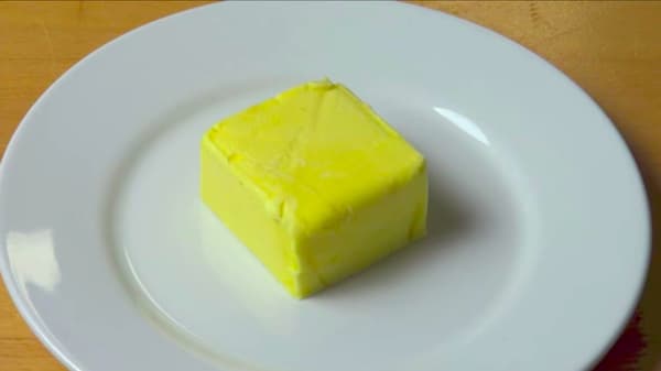 Aquí hay mantequilla dura en un plato blanco. ¿Cómo suavizarlo?