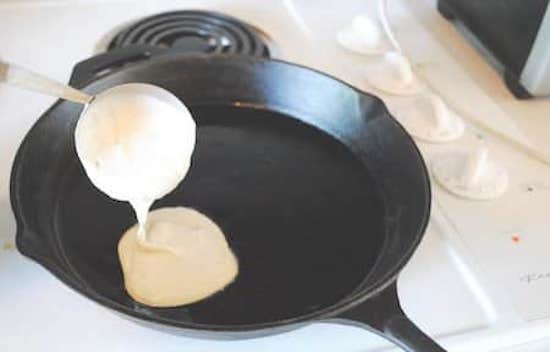 Zesde stap van het eenvoudige zelfgemaakte pannenkoekenrecept, verwarm de pan voor en giet het deeg erin.