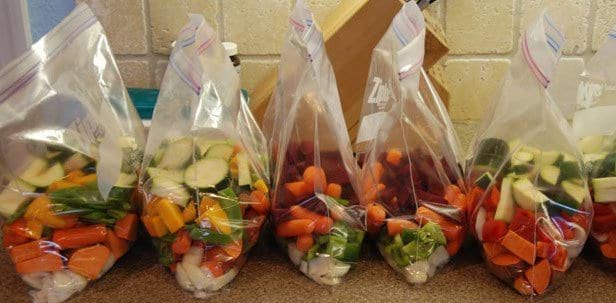 Paquetes de verduras cortadas en cubitos para guardar en el congelador.