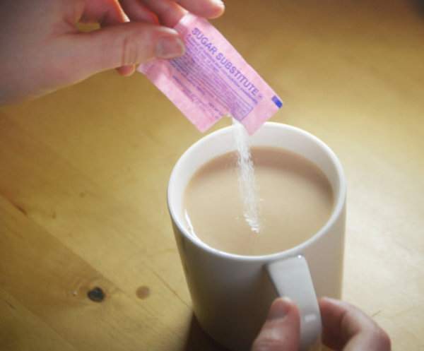en kvinde søder sin kaffe med saccharin