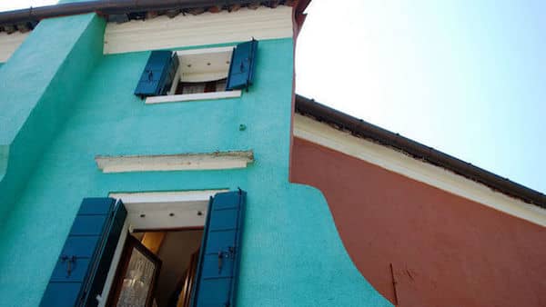 una fachada azul con ventanas abiertas