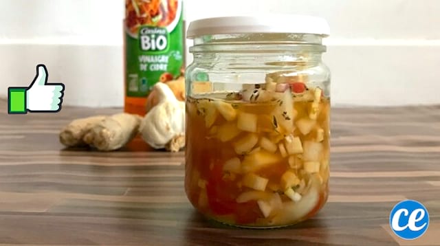 Un frasco con ajo, cebolla, jengibre en vinagre de sidra de manzana para hacer un antibiótico eficaz y natural.