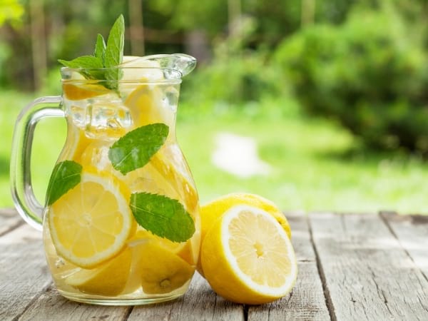 Una jarra de agua con limón sobre una mesa de madera para bajar de peso