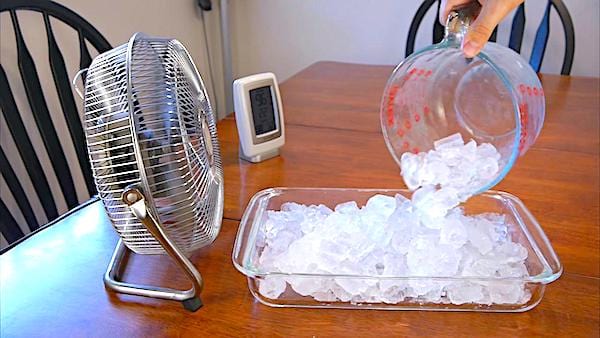 un ventilador frente a una bandeja de cubitos de hielo para enfriar una habitación rápidamente
