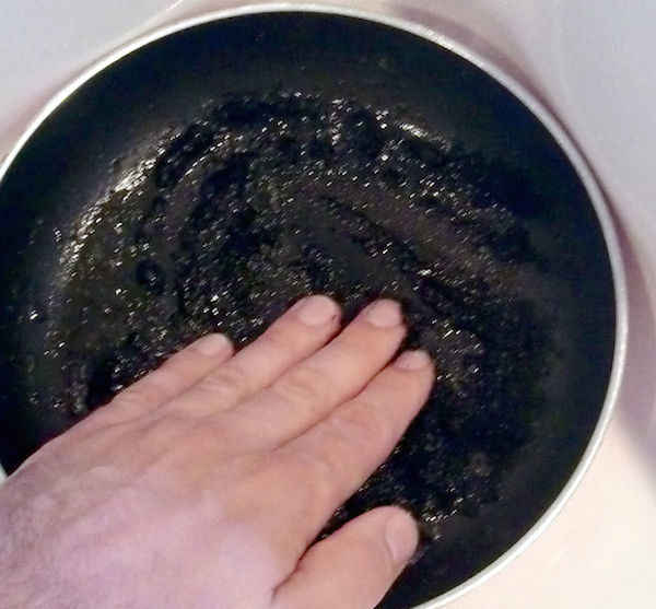 Limpiar una sartén quemada con posos de café
