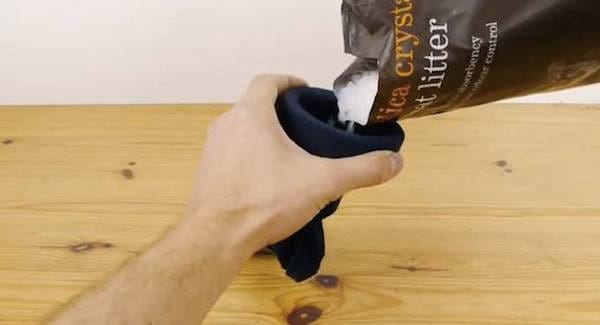 Llene el calcetín con arena para gatos que absorba la humedad